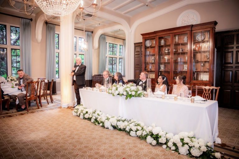 Wedding party seated at head table during toast