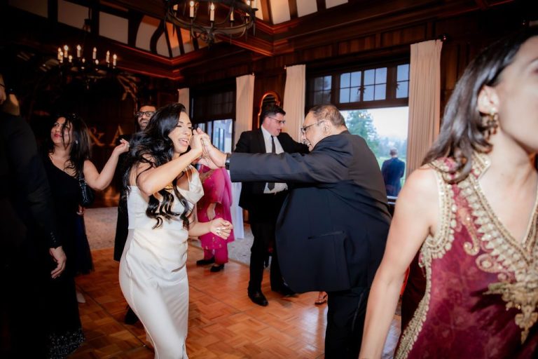 Bride twirling with guest on parquet dance floor