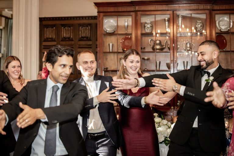 Guests dancing and embracing with arms outstretched