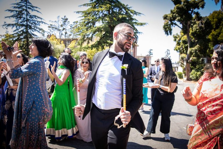 Man dances with guests in colorful procession