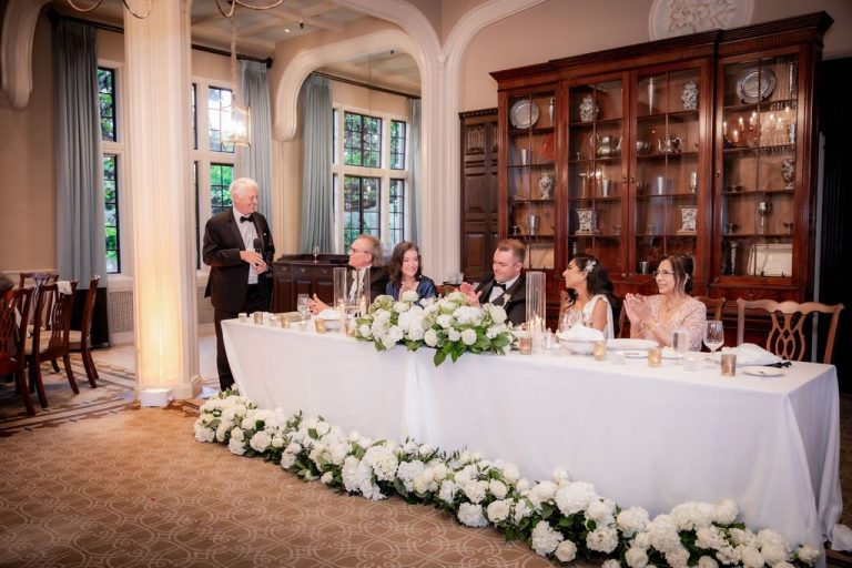 Head table toast with tall wood cabinet backdrop