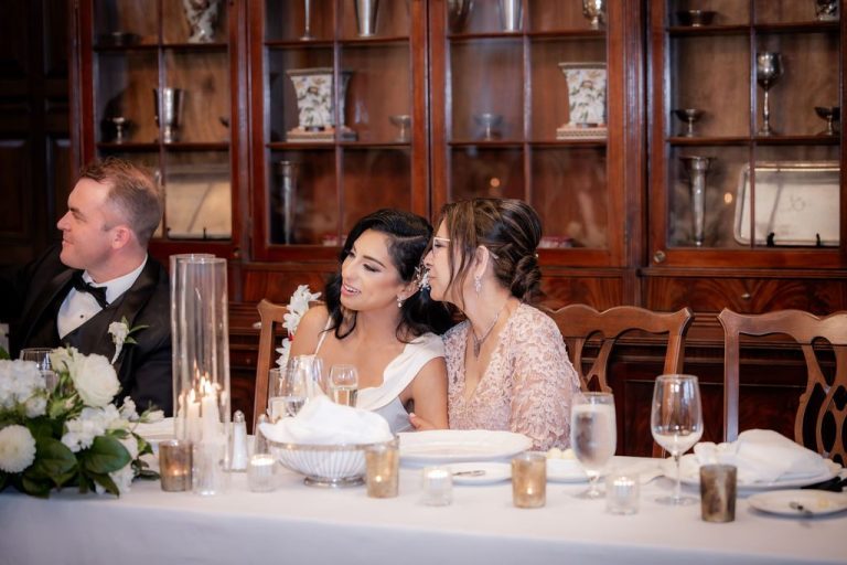 Bride and bridesmaid share moment at head table