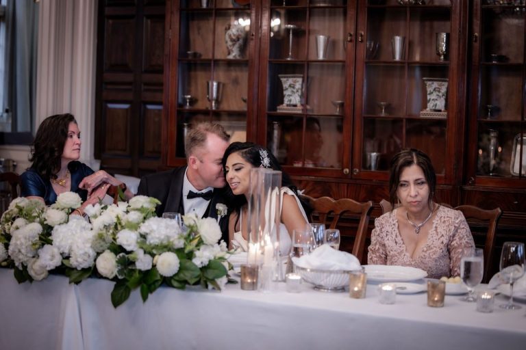 Guests seated at head table with white florals