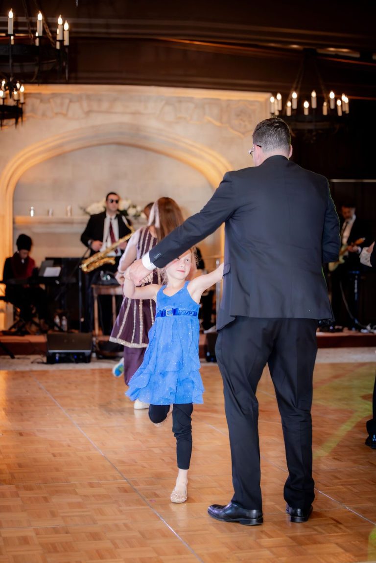 Man dancing with young girl in blue dress