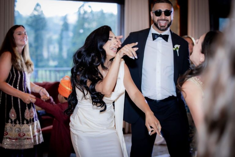 Bride and groom laughing while dancing together
