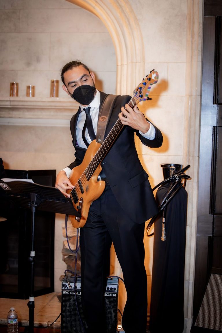 Bass guitarist performing near a fireplace