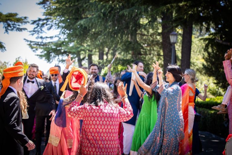 Guests in orange turbans dancing during procession
