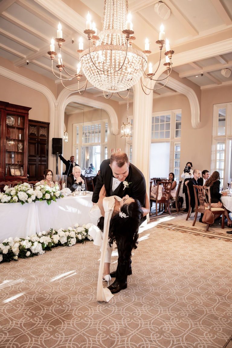 Groom dipping bride low during first dance