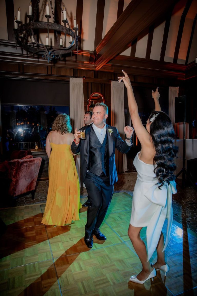 Guest dancing with arm raised in beamed hall