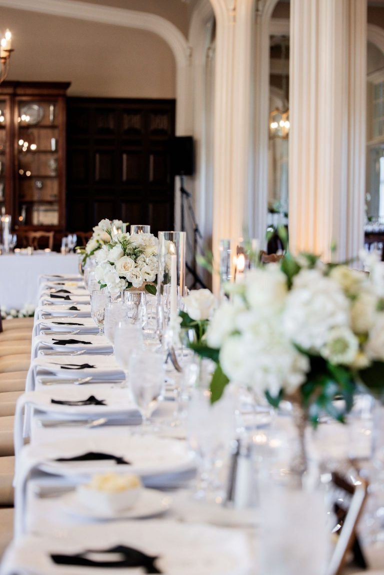 Long reception table with white florals and candles