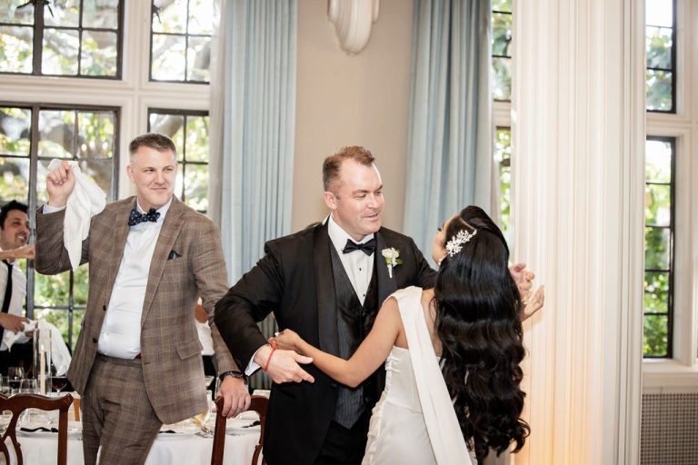 Groomsman greeting groom warmly during reception entrance