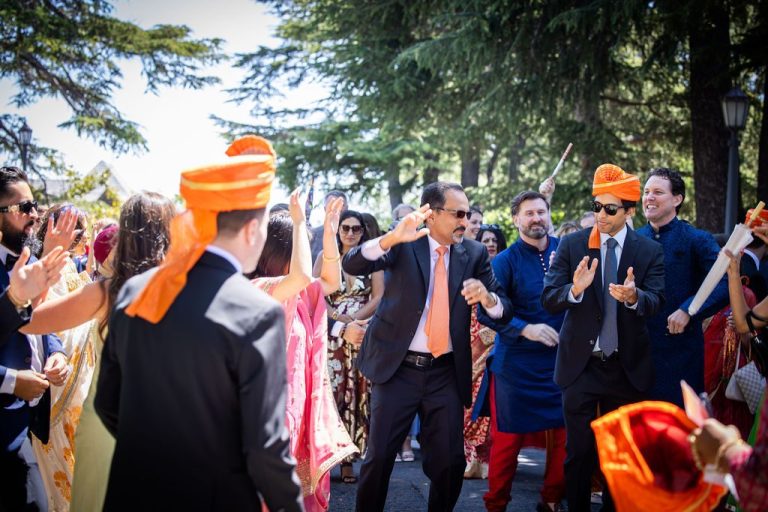 Festive baraat crowd dancing in orange turbans