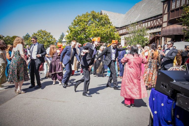 Guests dance on path near timbered building