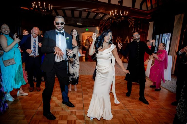 Bride dancing joyfully among guests in white gown