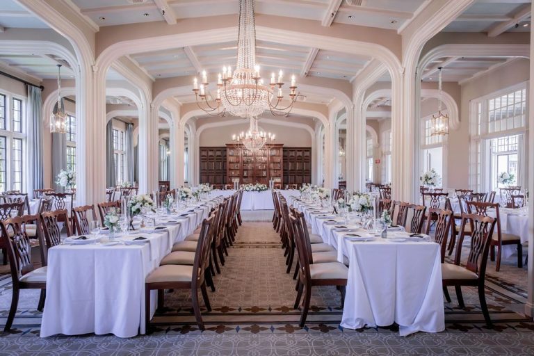 Long reception tables with white florals and chandeliers