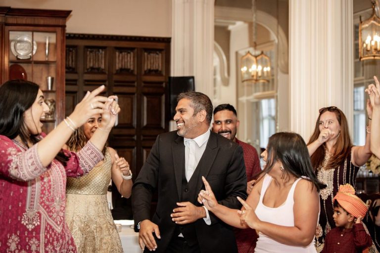 Guests dancing together with raised hands celebrating