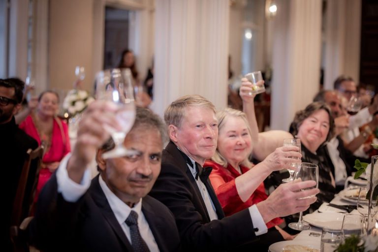 Table of guests raising glasses for a toast