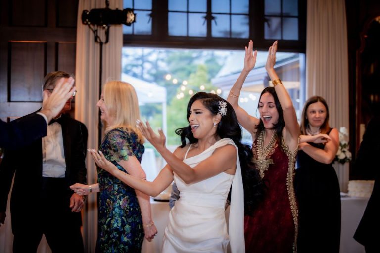 Bride clapping and dancing with cheering guests