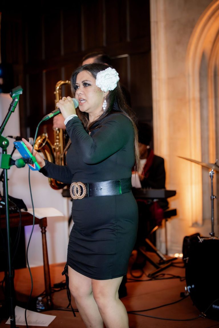 Vocalist in green dress singing with the band