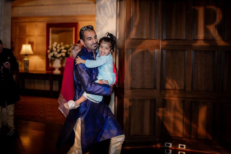 Man dancing while carrying young child