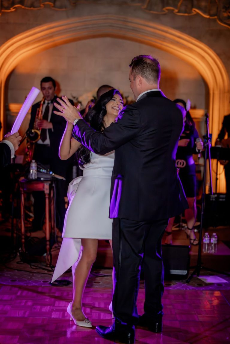 Bride and groom dancing near live band on floor