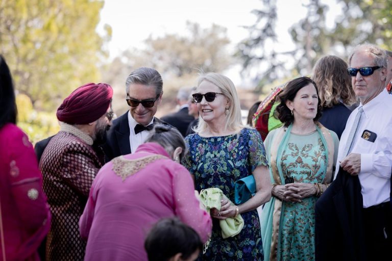 Guests mingling in colorful attire and sunglasses