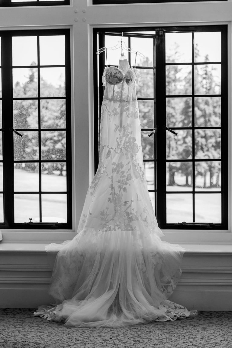 Black and white wedding gown hanging in window