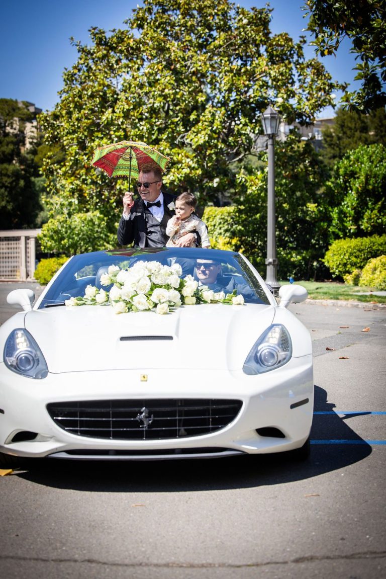 White sports car decorated with white rose florals on hood