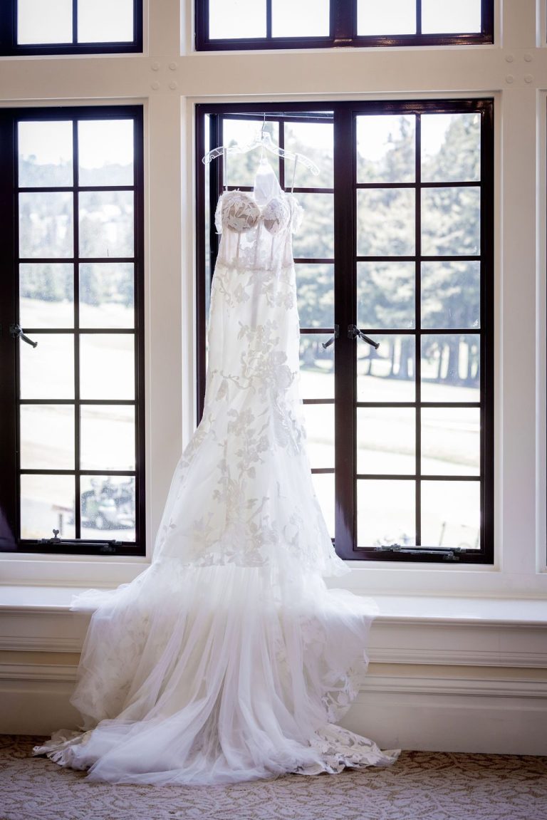 Lace gown hanging in dark leaded window frame