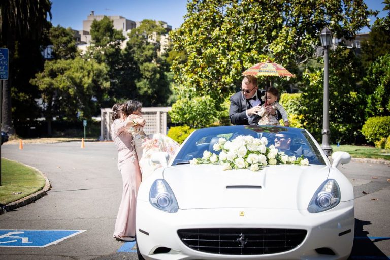 Decorated white sports car with guests and parasol nearby