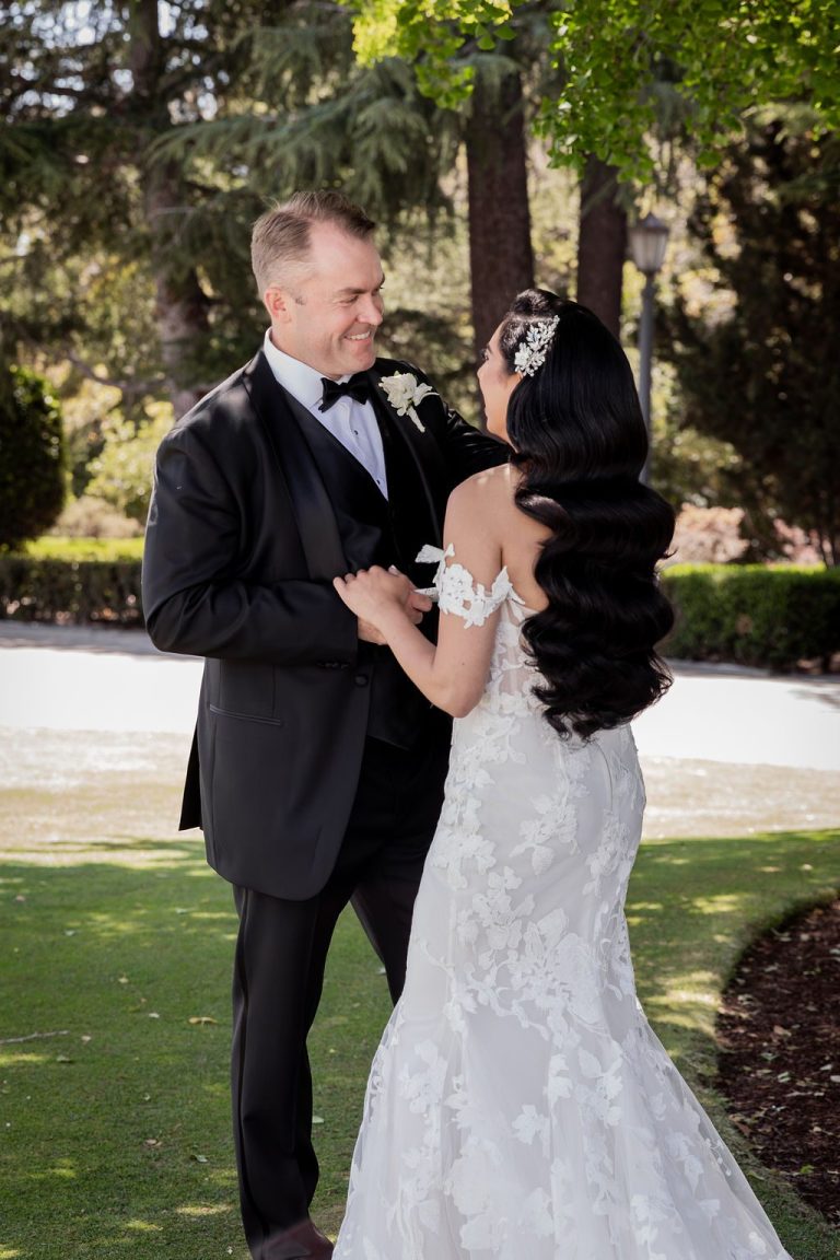 Bride and groom foreheads together under tree