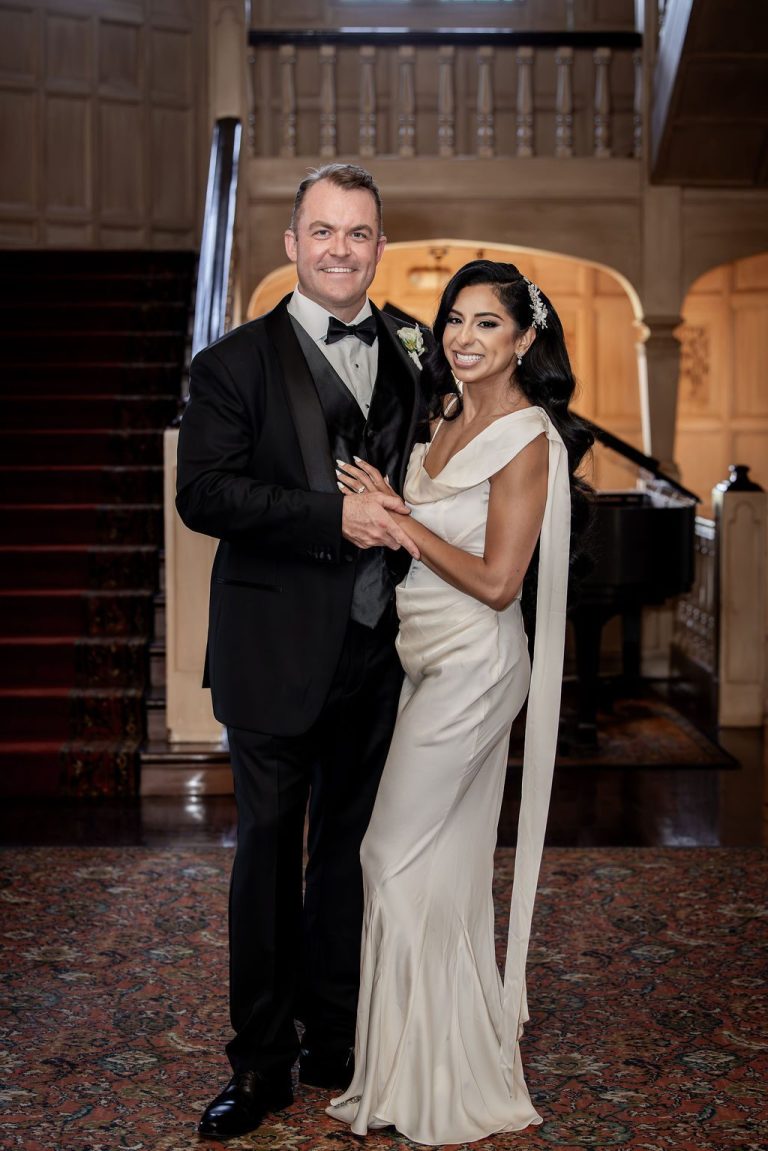 Bride and groom in evening attire by grand piano
