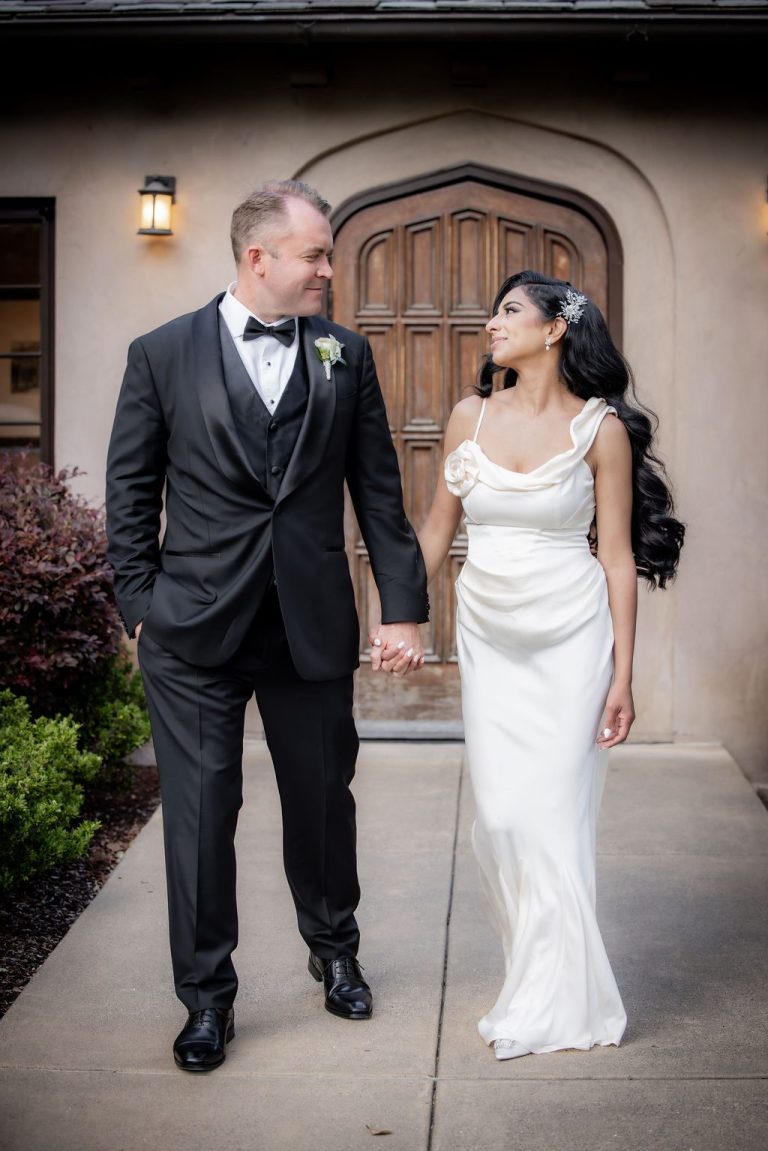 Bride and groom smiling walking hand in hand outdoors
