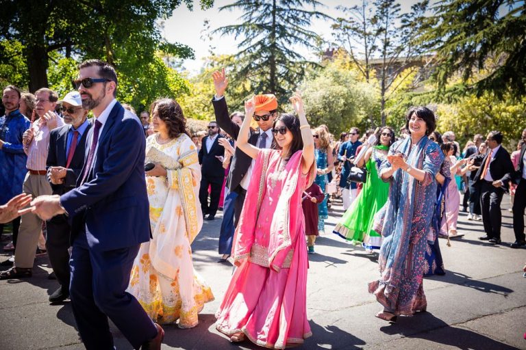 Guests wave and clap during outdoor procession