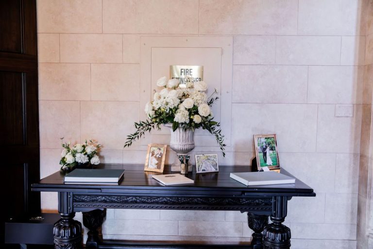 Guest book table with white florals and framed photos