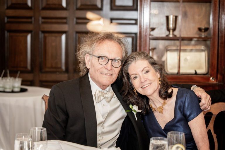 Older couple embracing and smiling at reception table