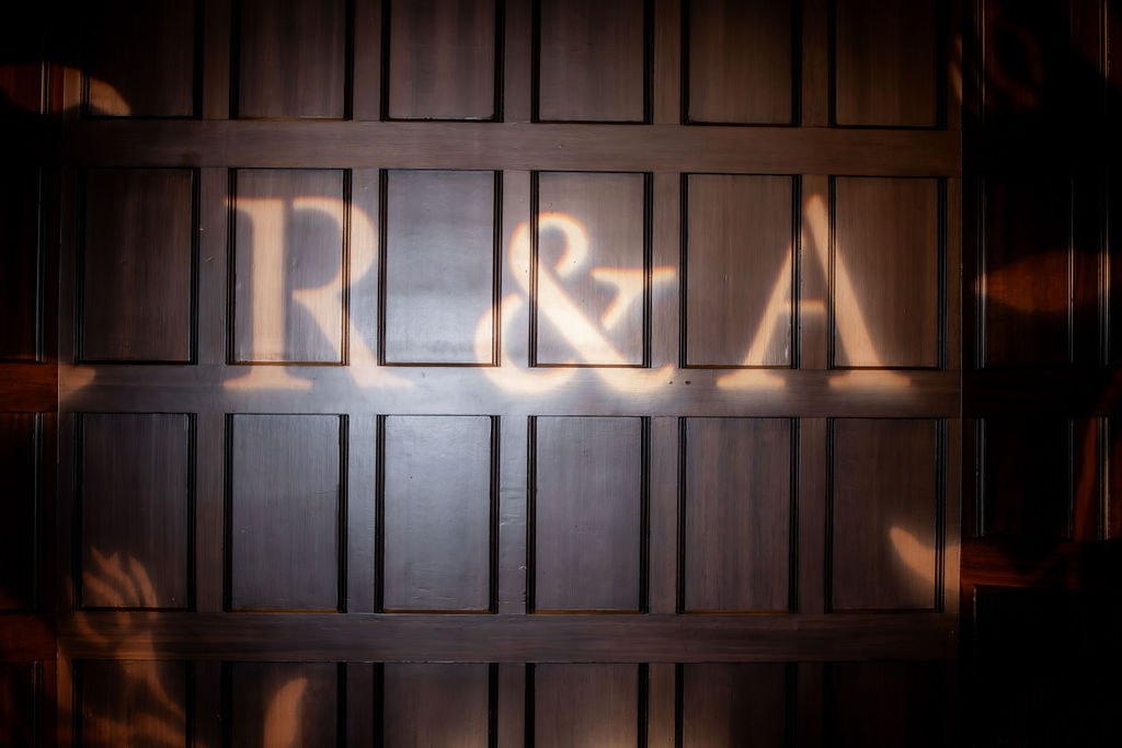 Illuminated R and A monogram on wood paneling