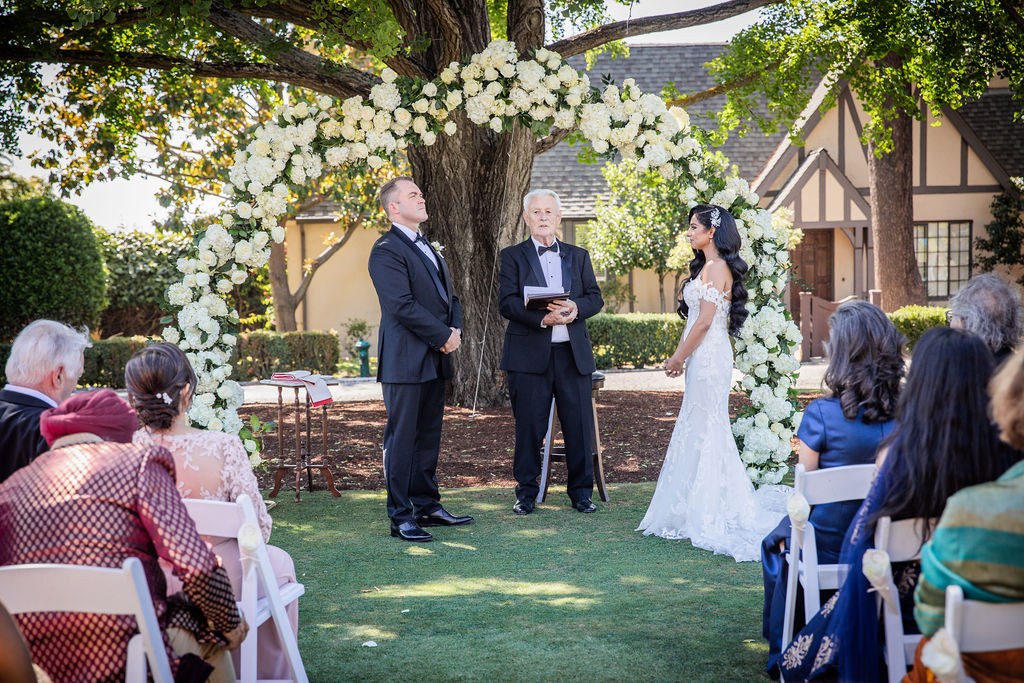 Bride and groom face each other during outdoor ceremony
