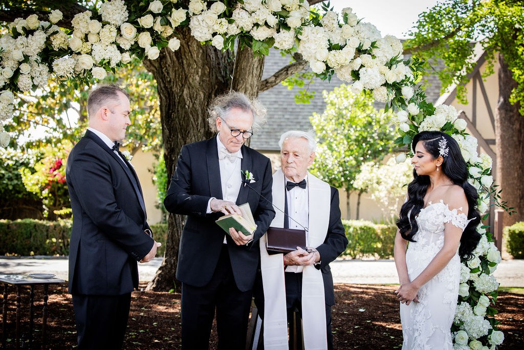 Officiant reading between attentive groom and bride