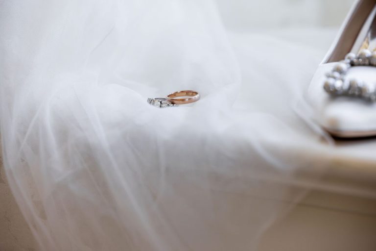 Wedding rings resting on soft tulle veil closeup