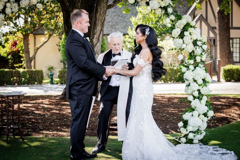 Bride and groom holding hands during outdoor vows