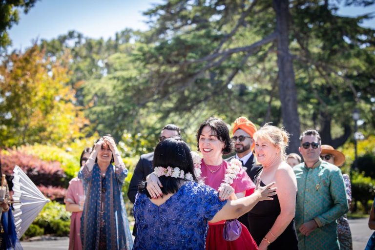 Woman laughing while embracing guest during greeting ritual