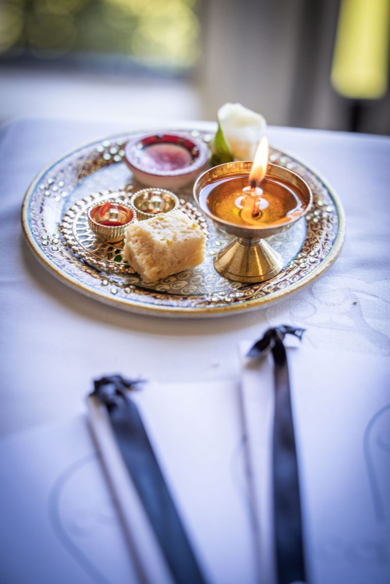 Ornate ceremony tray with lit lamp and offerings