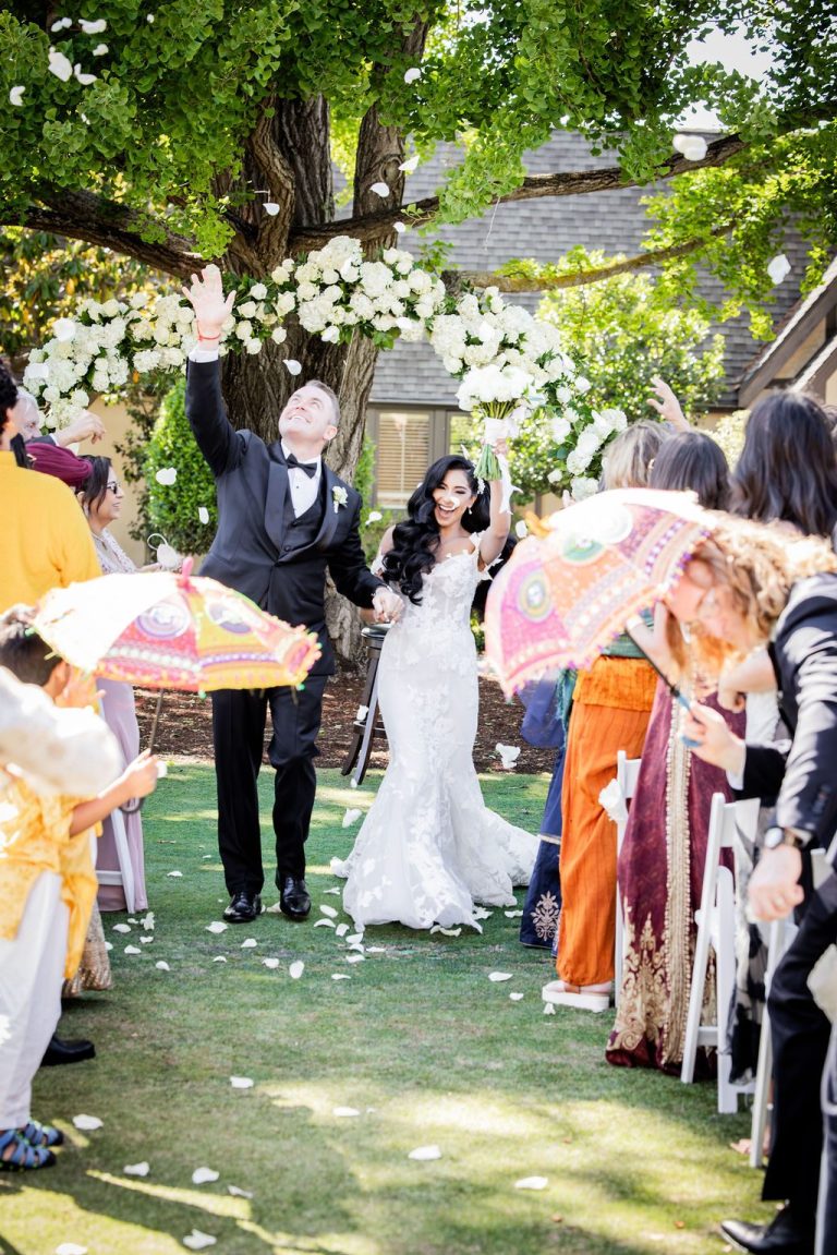 Recessional with guests waving colorful parasols and petals