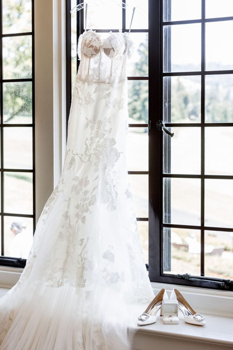 Long lace gown hanging in dark leaded window