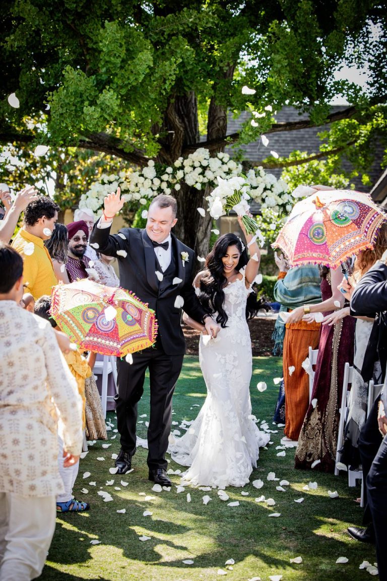 Joyful petal exit with couple and cheering guests