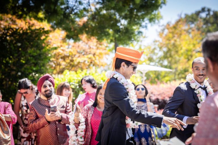 Men greeting with floral garlands in bright sunlight