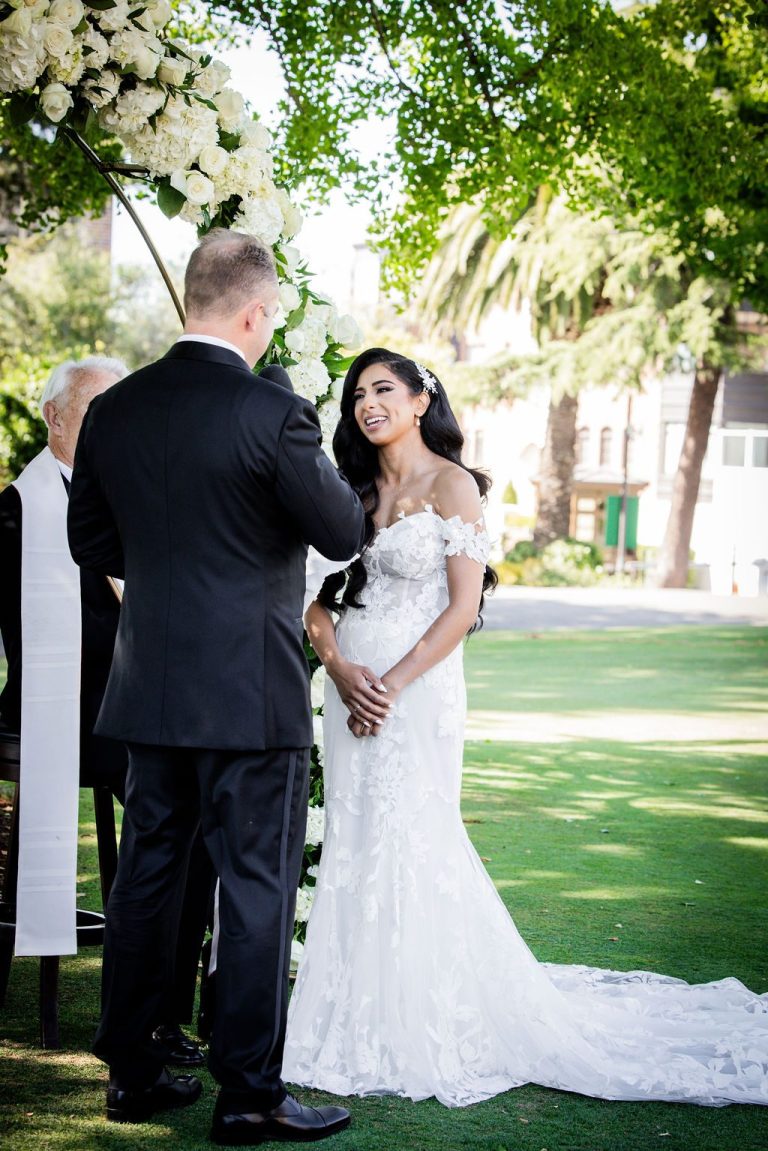 Groom and bride holding hands with officiant nearby