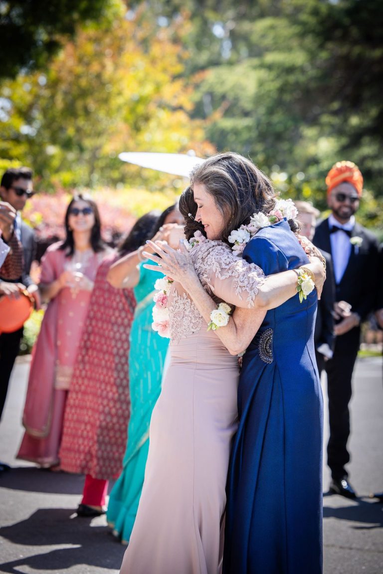 Two women embracing tenderly with garland during greeting