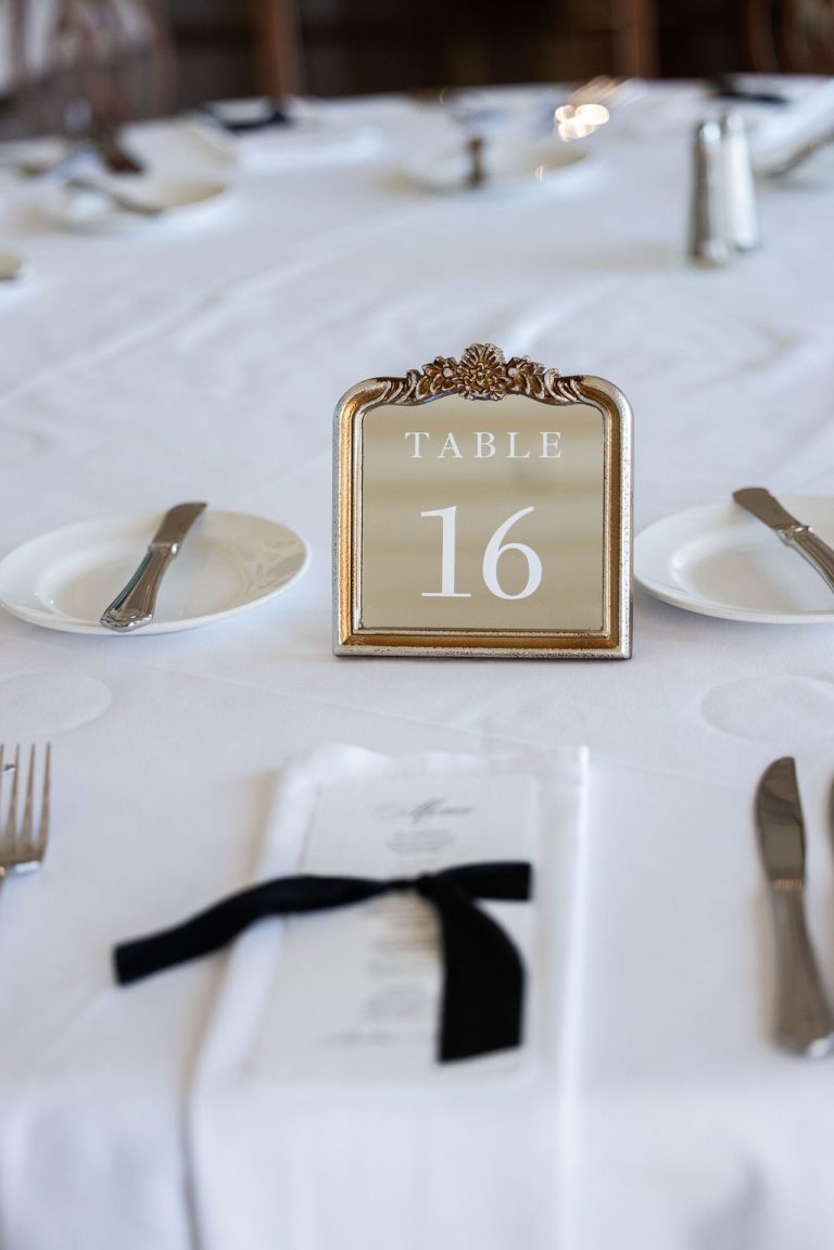 Table number sixteen with menu and black ribbon napkin